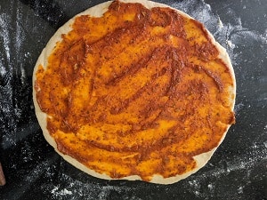 spreading pizza sauce