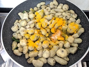 cooked Koorka added with the tempering along with turmeric and salt
