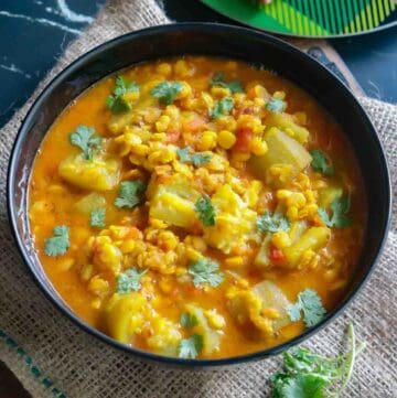 lauki chana dal served in a black bowl garnished with coriander leaves