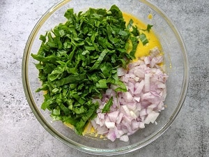 Moong chilla batter with chopped spinach and onions