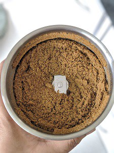 Finely ground roasted cumin powder in a grinder jar