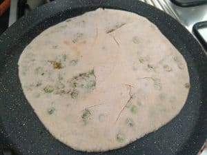 Potato Peas Paratha cooking on a hot tava