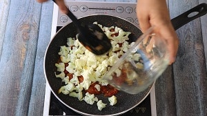 Blanched cauliflower added to the onion tomato masala