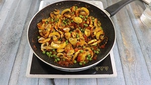 sauteeing the mushroom and peas with spices