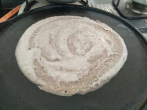Oats Millet Dosa cooking on Hot griddle