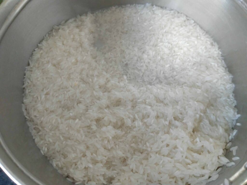 Rinsing short grain ponni rice for making coconut rice