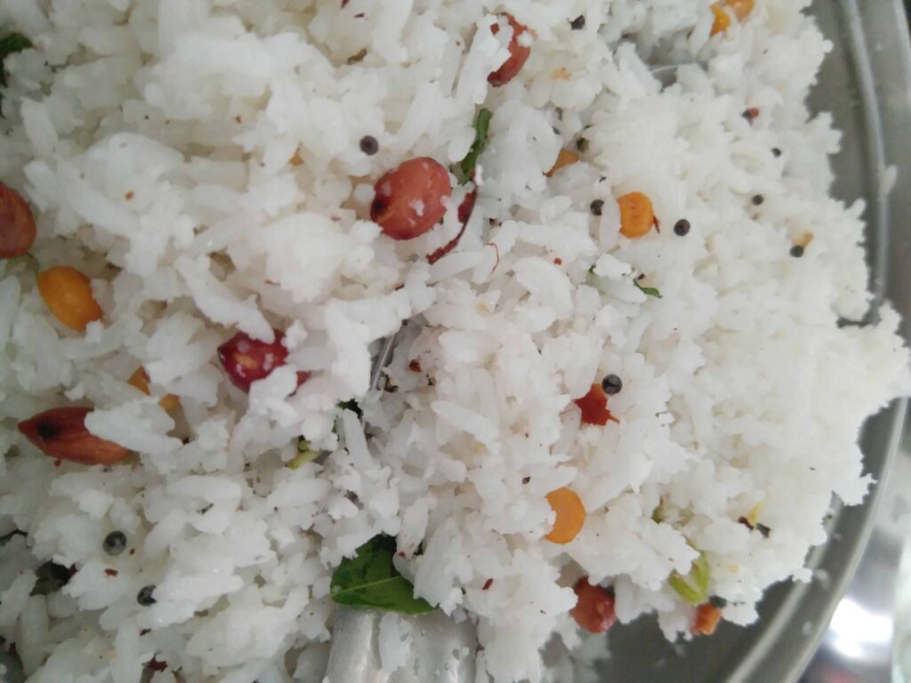 mixing the rice with fresh coconut and tempering