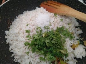 Mixing of poha into the sauteed mixture of onions and potatoes