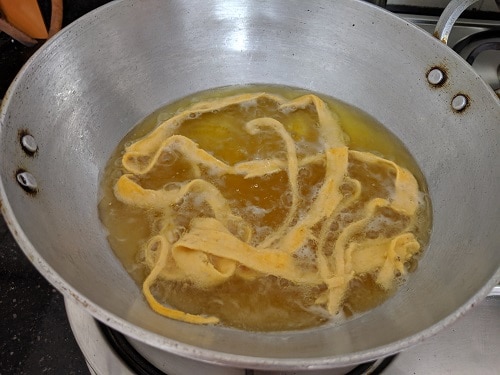 Fry the Ribbon Pakoda on low flame until crunchy and crisp