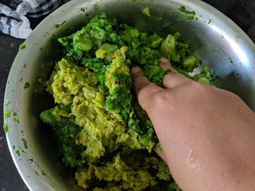 Mashing potato and peas with spinach