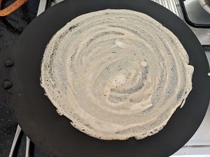 Crispy Brown Rice Dosa cooking on hot pan