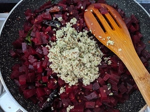 Adding the coconut mix to the thoran