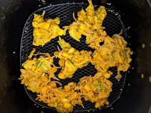place the pakodas in the air fryer basket after greasing with oil
