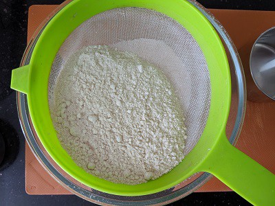 Sifting the whole wheat flour for banana bread