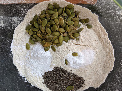 Baking powder, baking soda, chia seeds and pumpkin seeds added to whole wheat flour