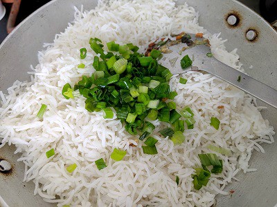 Adding the basmati rice with spring onion greens to the mixed vegetables