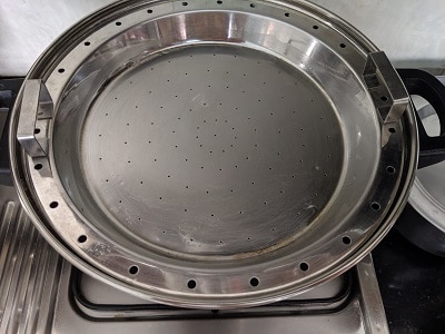Preparing the steamer by greasing the steamer plate