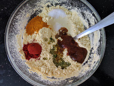 Adding spices and salt to the chickpea flour