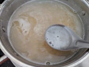 Cooking the chana dal and removing the foamy layer on top