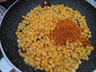 Adding the cooked chana dal with sundal podi to the tempering