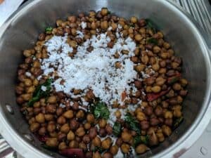 Adding freshly grated coconut to the Kondakadalai Sundal