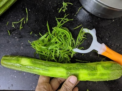 Peeling the Peerkangai or Ridge Gourd