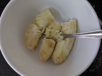 Over Ripe bananas being mashed with a fork
