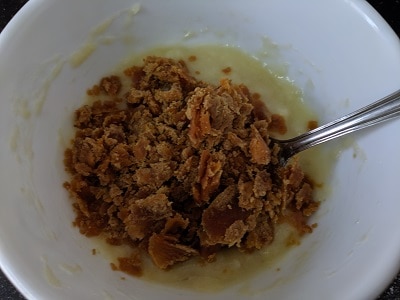 Adding jaggery to the mashed bananas