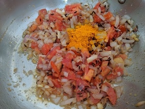 cooking the onion and tomatoes with turmeric powder