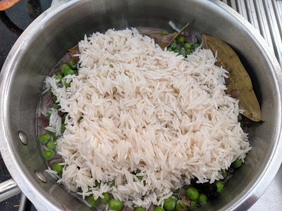 Mixing basmati rice with peas and spices