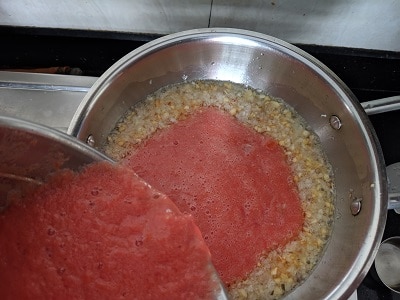 Tomato puree added to the onion garlic mix