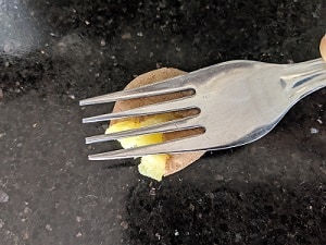 smashing the potatoes using a fork