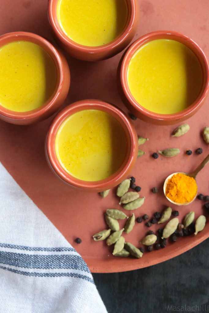 4 cups of turmeric milk or haldi doodh served in earthen mugs or kulhad.