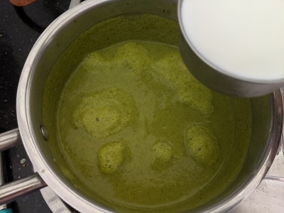 Adding milk to the broccoli soup