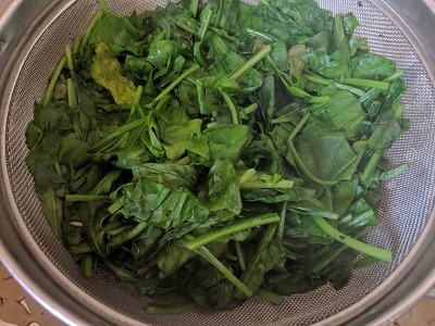 Draining the cooked spinach