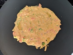 Cooking the tomato omelette on hot griddle