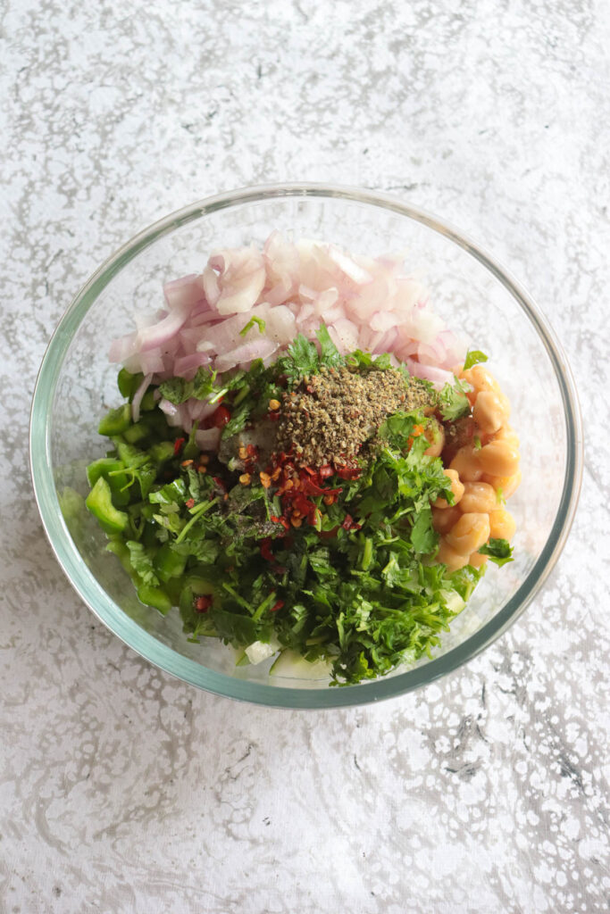 Chickpea salad assembled in a bowl mixed with herbs and seasoning
