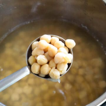 A ladle full of cooked chickpeas in the instant pot