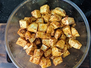 tossing the potatoes with seasoning and oil