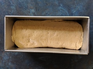bread set aside for proving in the bread tin