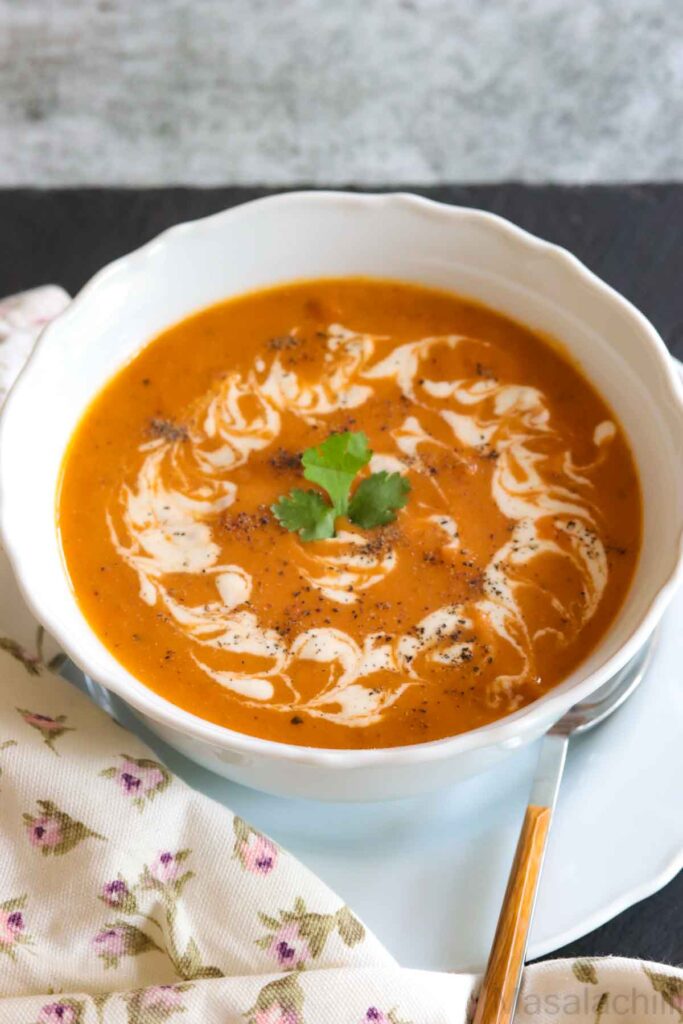 White bowl with Tomato Soup garnished with cashew cream