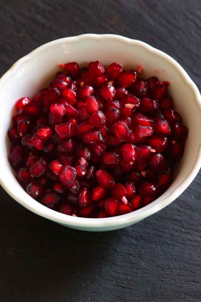 A white bowl filled with pomegranate arils
