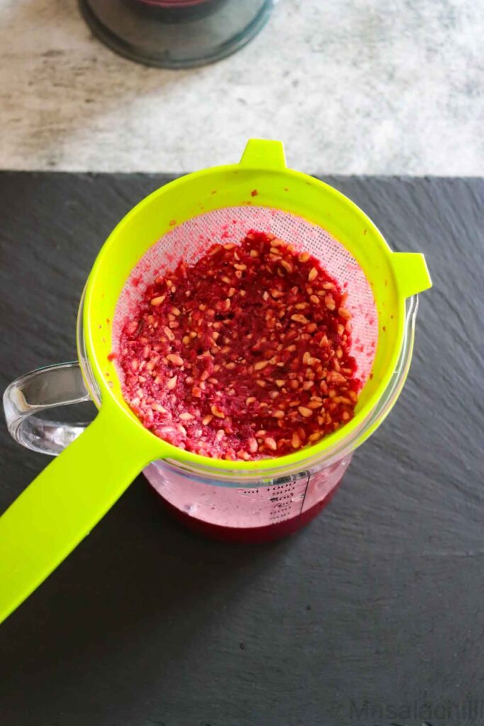 Straining the pomegranate juice to remove seeds
