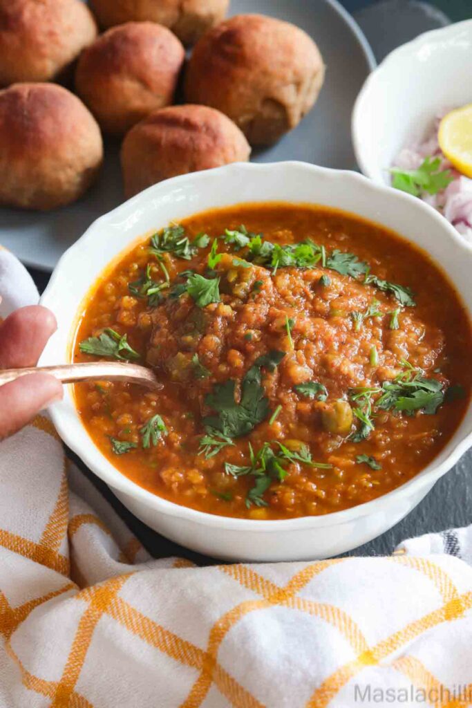 Instant Pot Pav Bhaji served in a white bowl with whole wheat dinner rolls