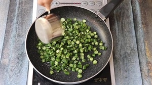 Stir frying Vendakkai in a wide pan