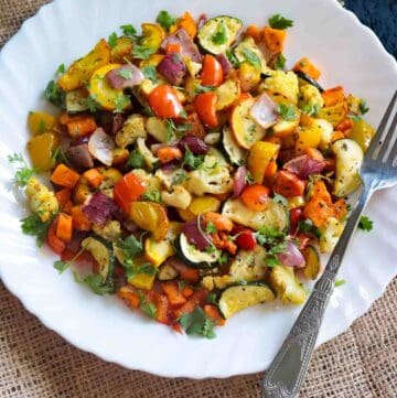 White plate with air fried vegetables garnished with fresh cilantro
