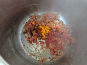 Sautéing the onion and tomatoes with dry spices