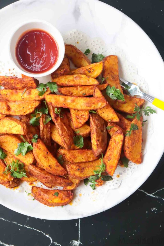 Air Fryer Potato Wedges served in a white plate with tomato ketchup