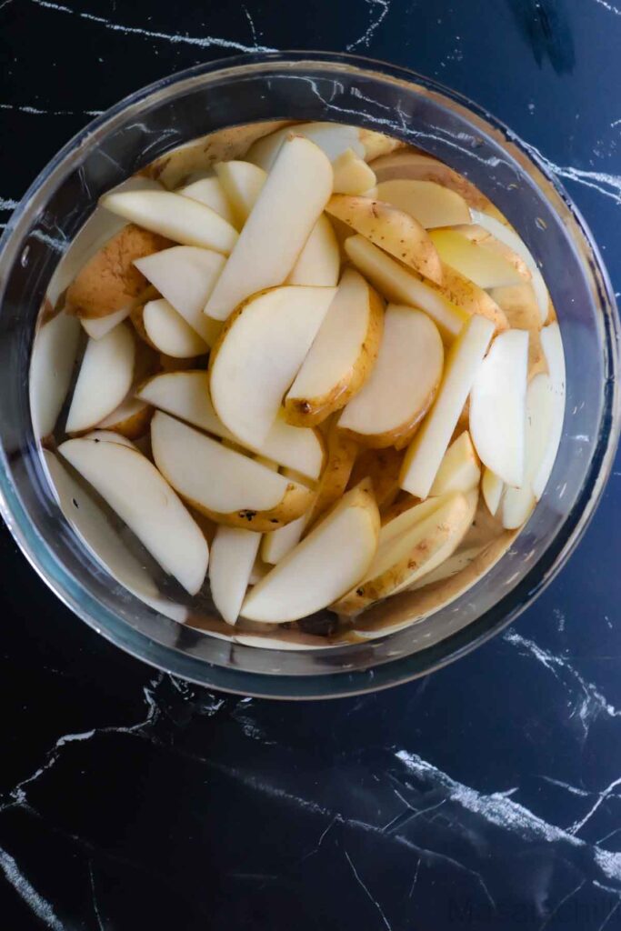 soaking the potatoes in cold water to make crispy potato wedges
