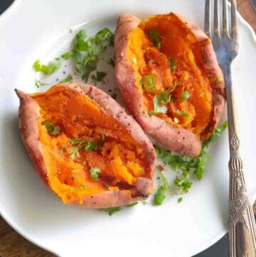 2 Baked Orange sweet potato served on a white plate garnished with cilantro, black pepper, red chili flakes and salt